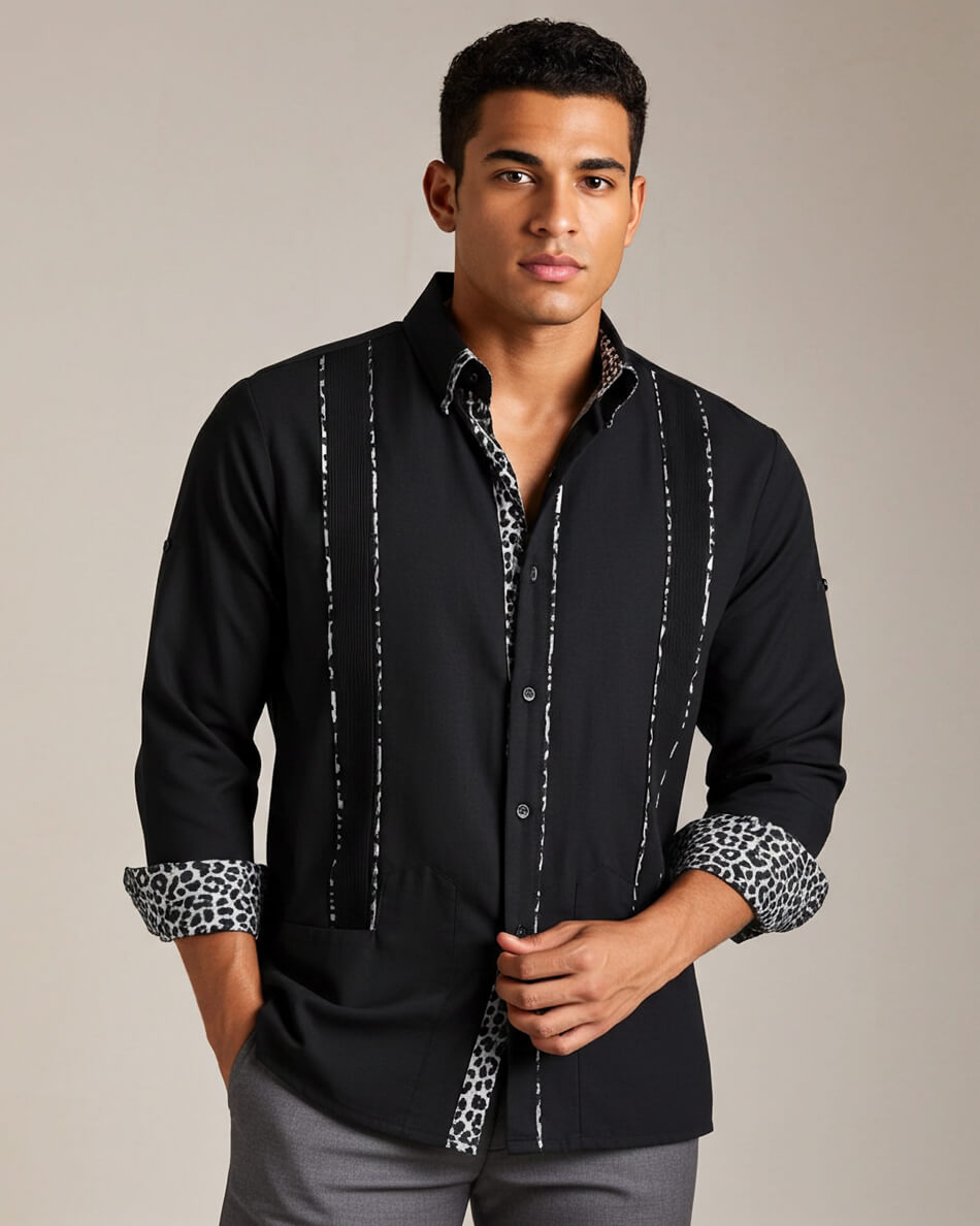 Man wearing a black guayabera leopard shirt with rolled-up sleeves on a beige background