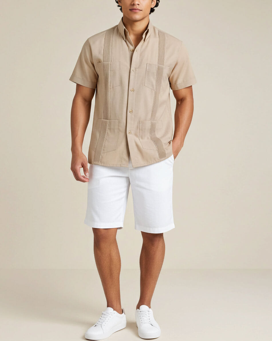 Man wearing a beige short-sleeve guayabera shirt and white shorts on a beige background