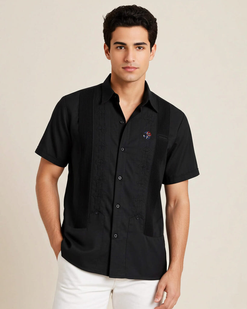 Man wearing a black short-sleeve shirt with a small logo on a beige background