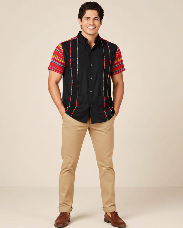 Man wearing a black guayabera shirt with zarape sleeves against a beige background