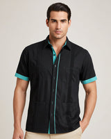 Man wearing a black guayabera shirt with teal accents on a plain background