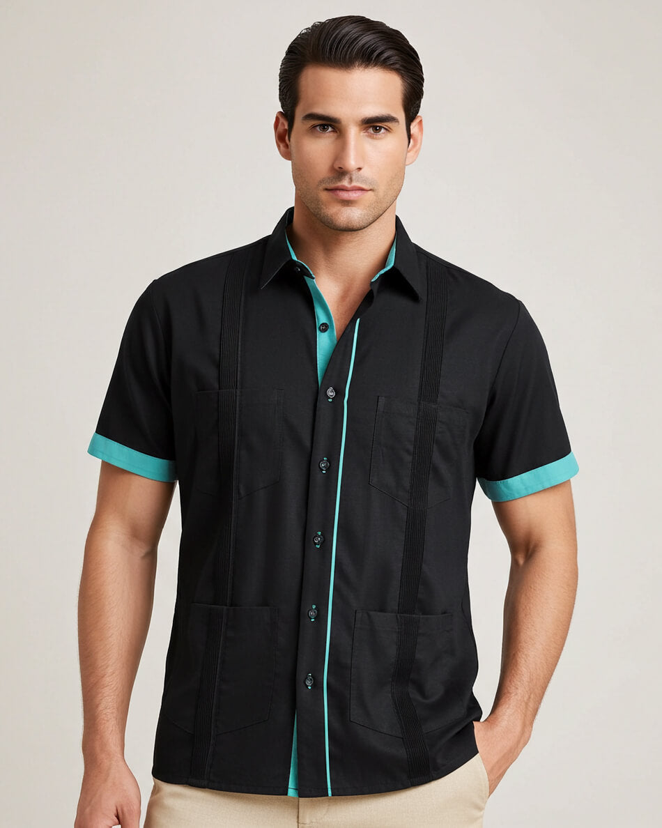 Man wearing a black guayabera shirt with teal accents on a plain background
