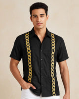 Man wearing a black shirt with gold chain details on a beige background