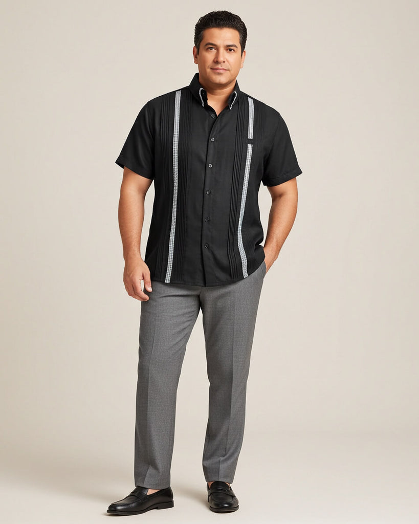 Man wearing a black shirt with houndstooth stripes and gray pants on a beige background