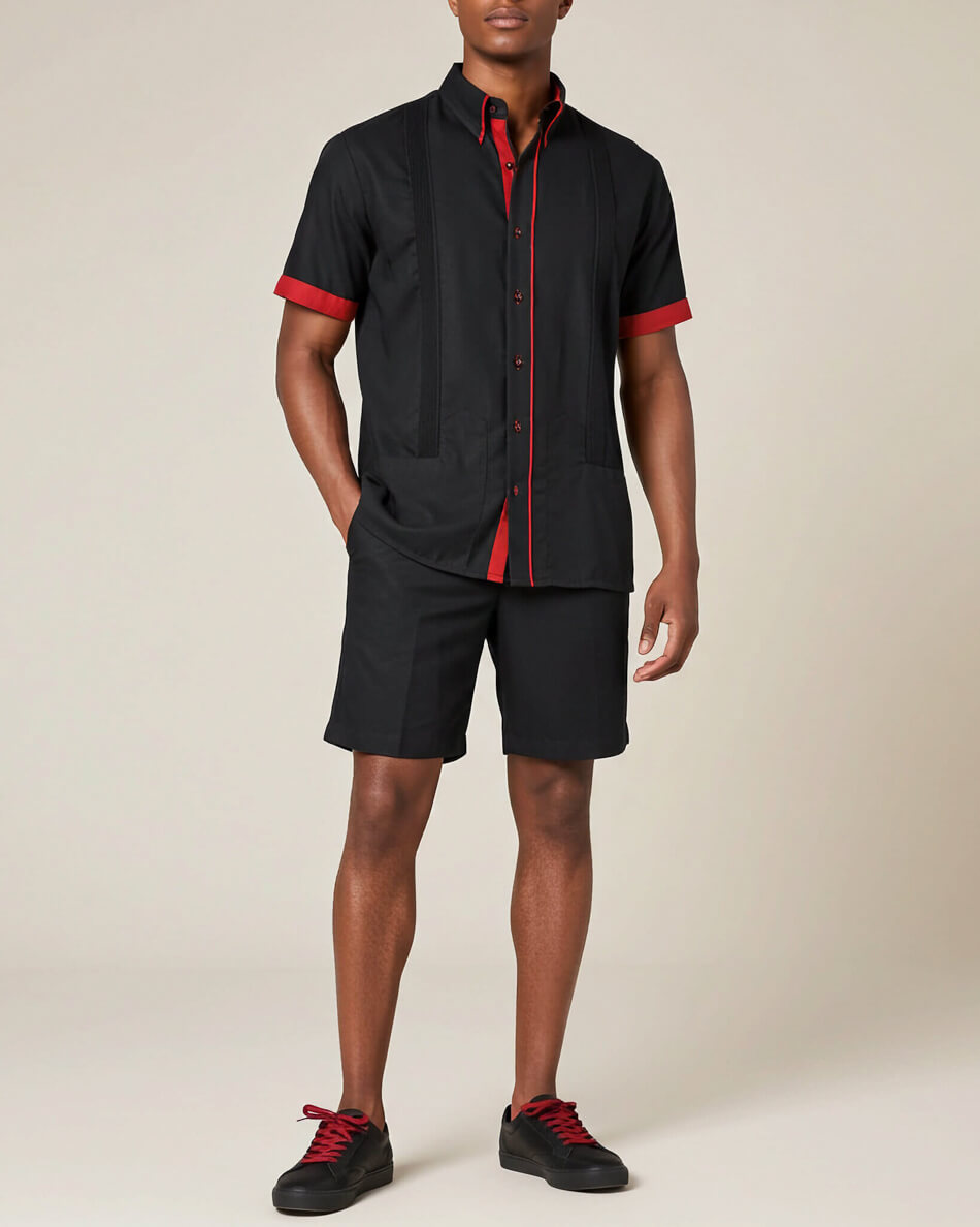 Person wearing a black outfit with red accents on a beige background