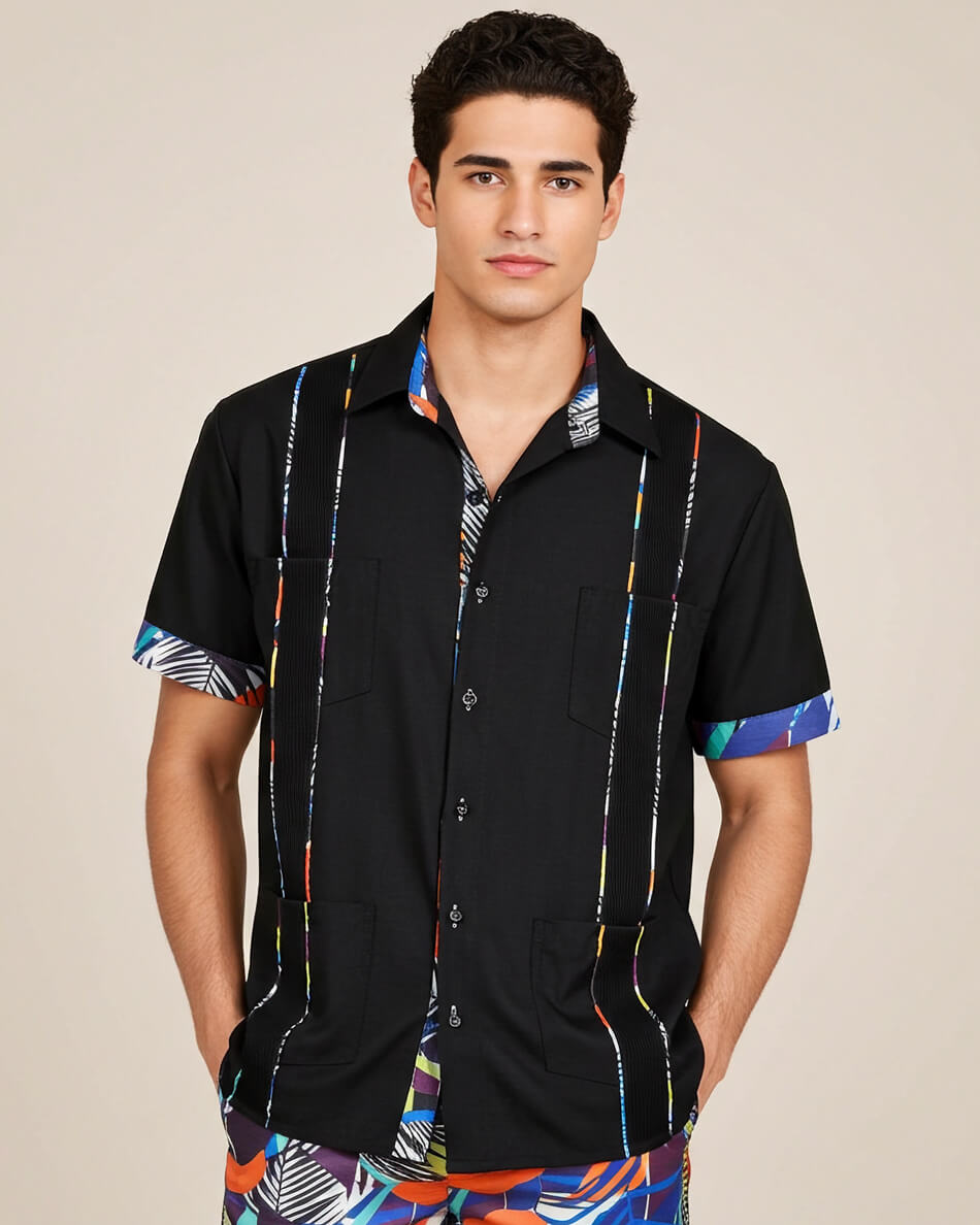 Man wearing a black guayabera shirt with colorful trim on a beige background