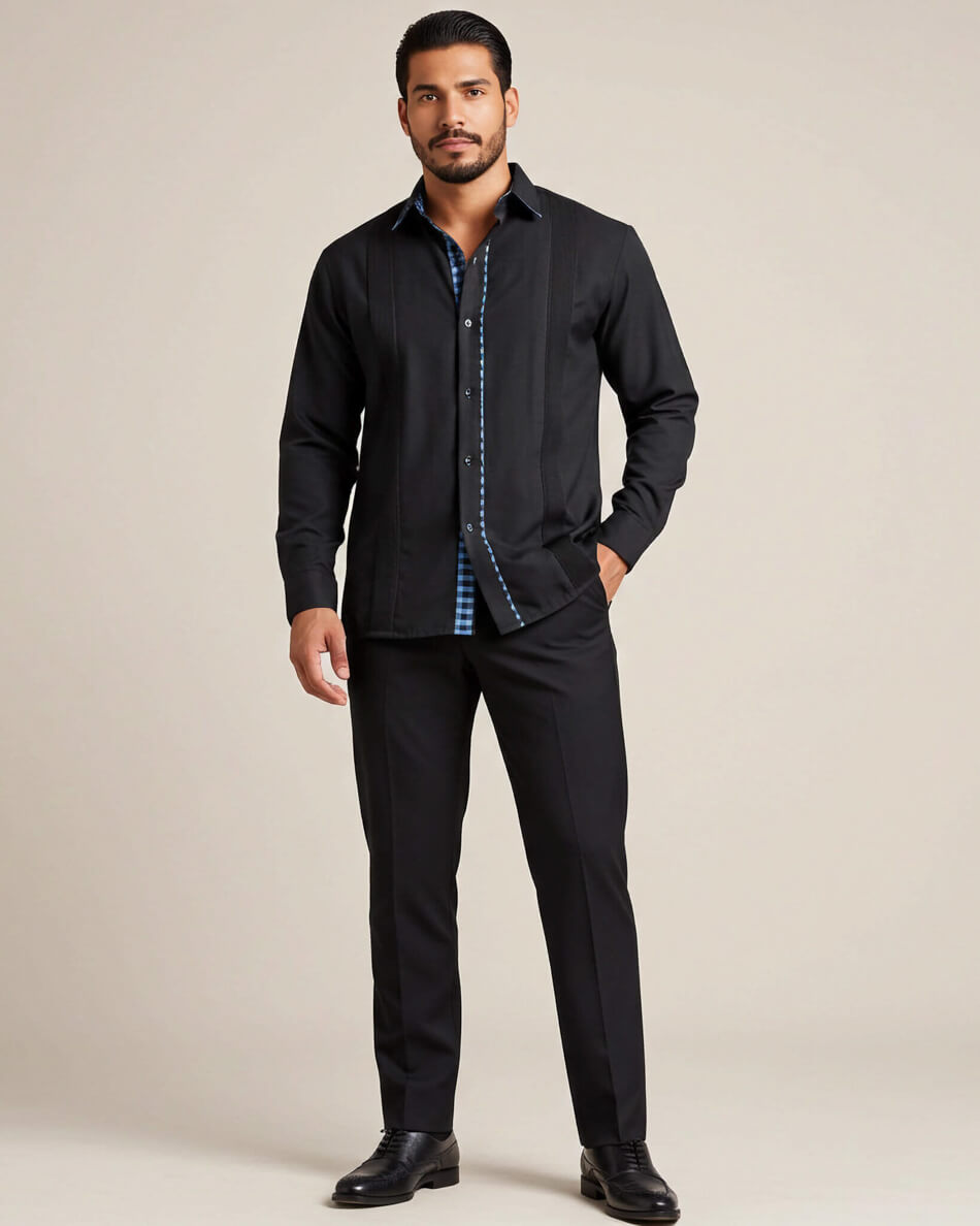 Man wearing a black long sleeve guayabera shirt with turquoise gingham accents on a beige background