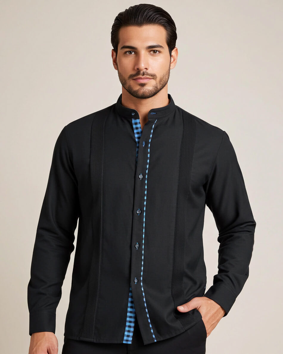 Man wearing a black guayabera shirt with turquoise gingham accents on a beige background