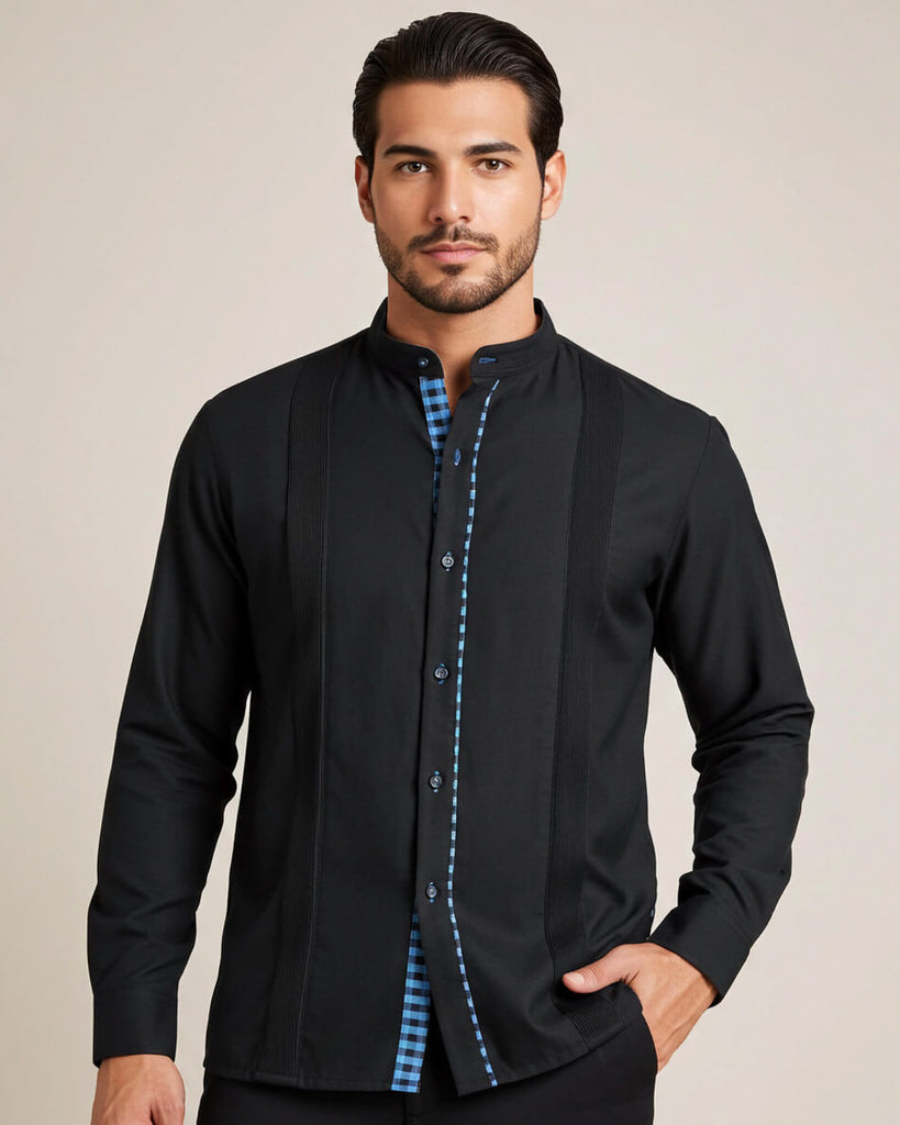 Man wearing a black guayabera shirt with turquoise gingham accents on a beige background