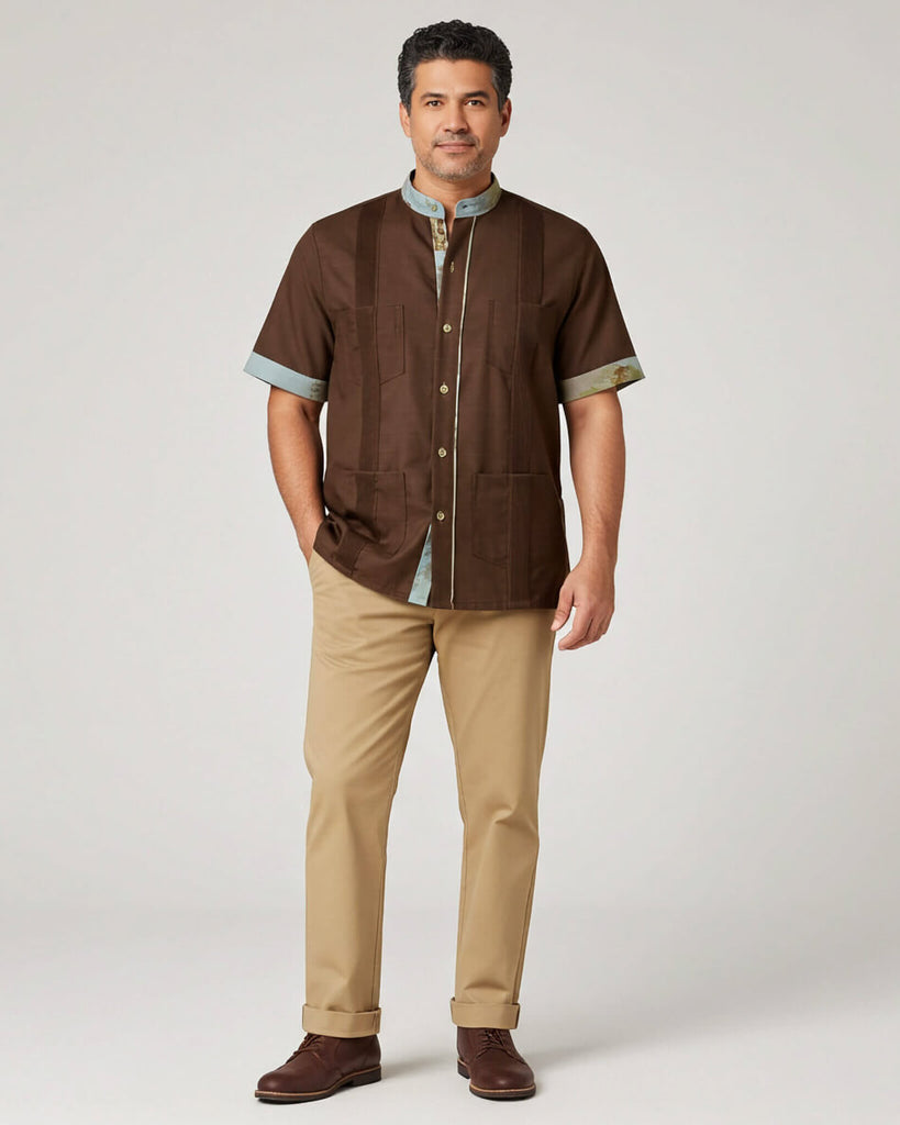 Man wearing a brown shirt with green trim and beige pants on a white background
