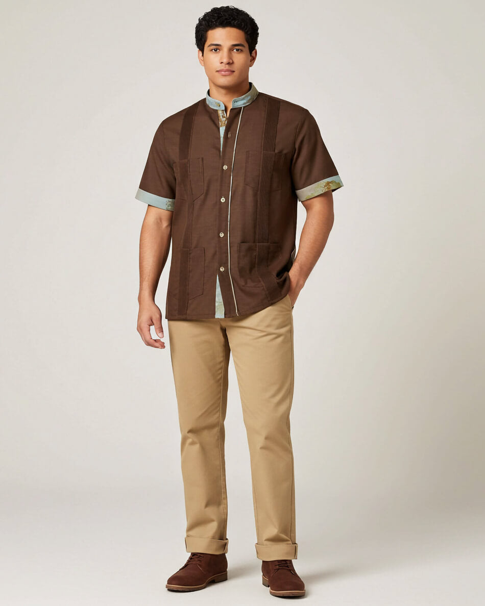 Man wearing a brown shirt and beige pants against a white background