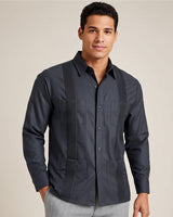 Man wearing a dark grey long-sleeve guayabera shirt on a beige background