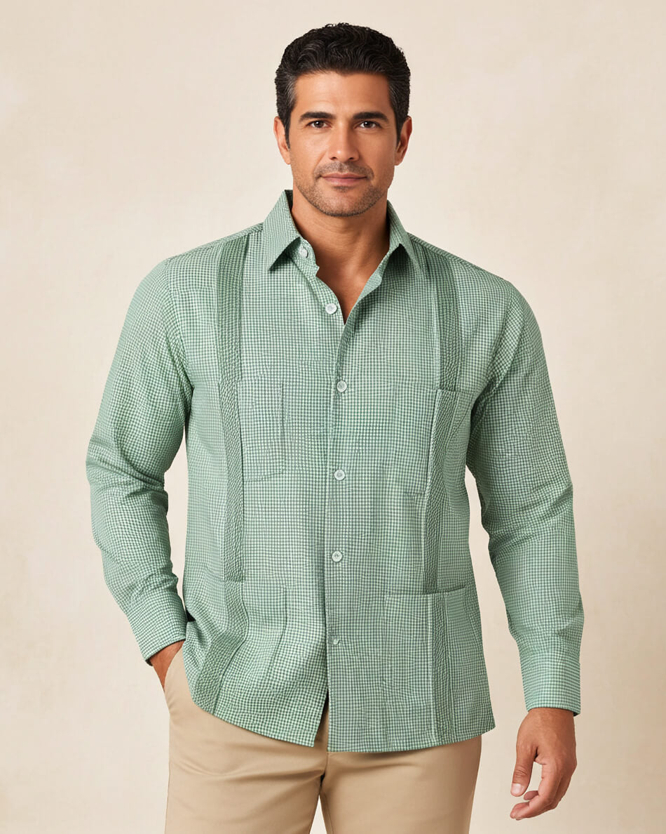 Man wearing a green checkered guayabera shirt against a beige background