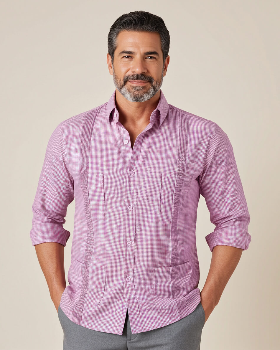 Man wearing a pink guayabera checkered shirt against a beige background