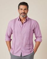 Man wearing a pink guayabera checkered shirt against a beige background