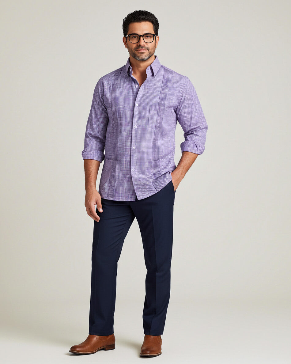 Man wearing a purple gingham guayabera shirt and navy pants on a light gray background
