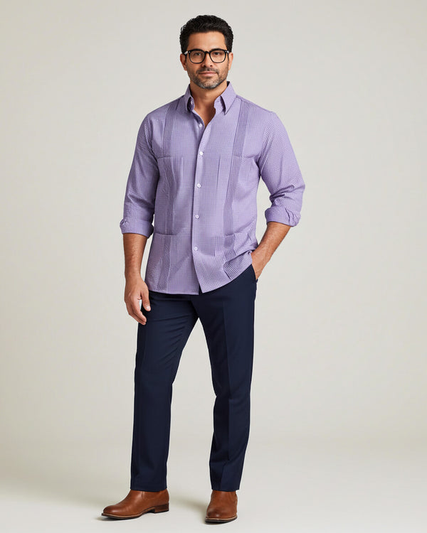 Man wearing a purple gingham guayabera shirt and navy pants on a light gray background