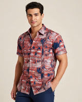 Man wearing a patterned guayabera shirt against a beige background