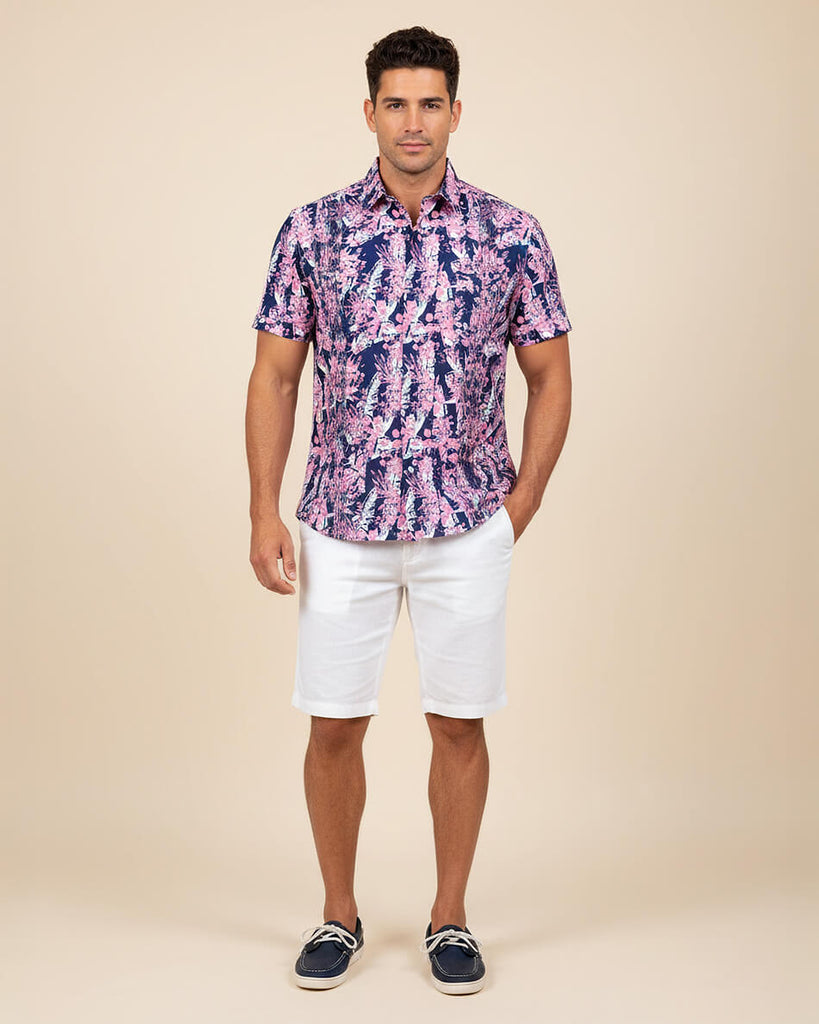 Man wearing a patterned shirt and white shorts on a beige background