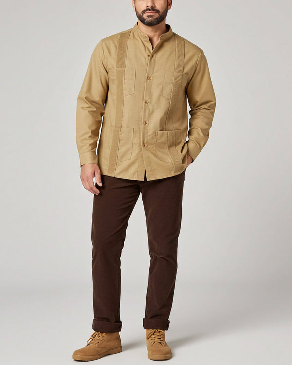 Man wearing a khaki guayabera shirt and brown pants on a plain background