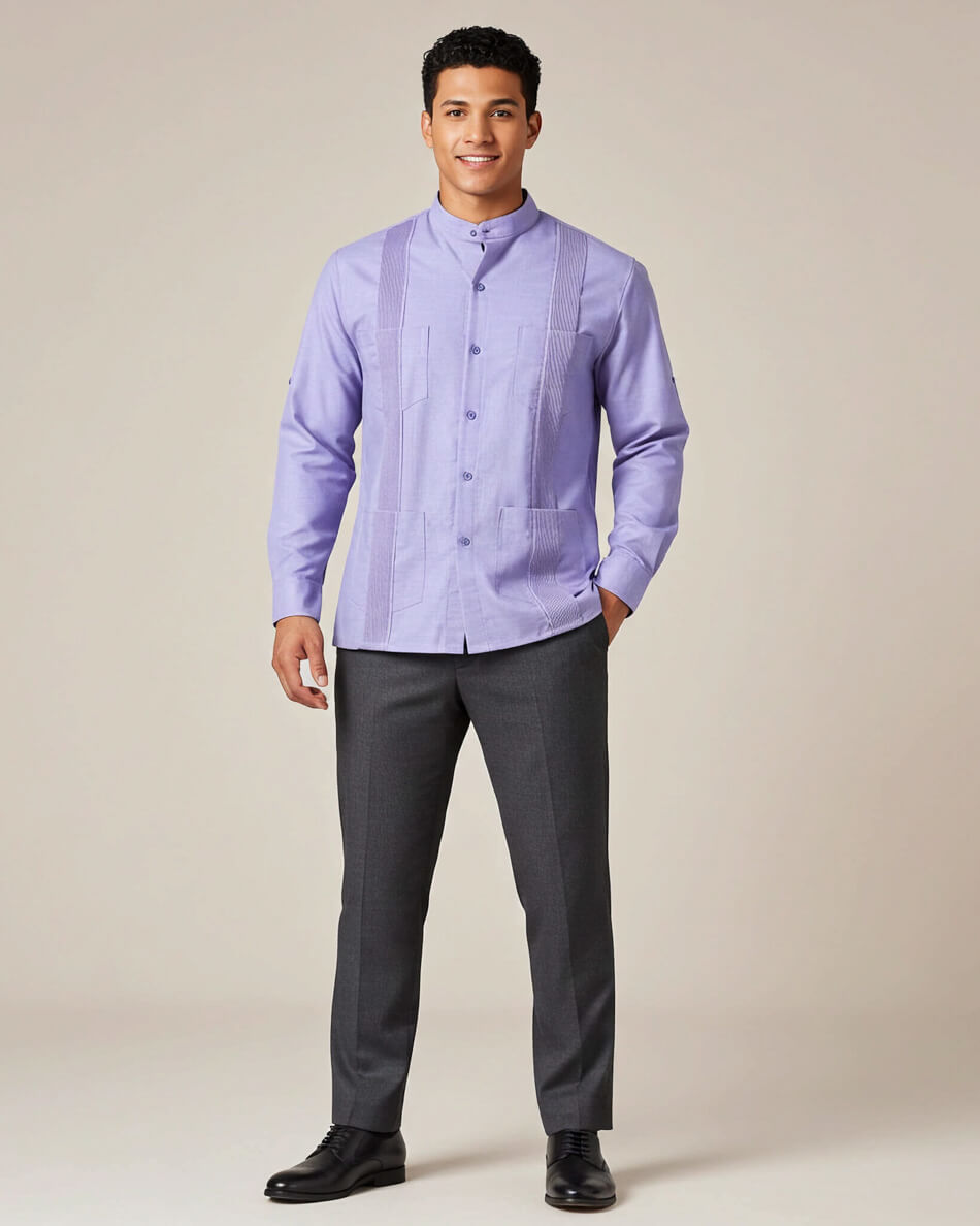 Man wearing a light purple long-sleeve guayabera shirt and dark gray pants on a beige background