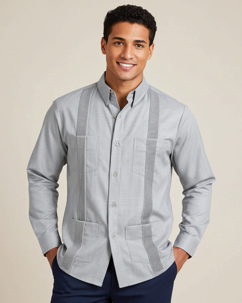 Man wearing a light gray guayabera shirt with vertical stripes on a beige background