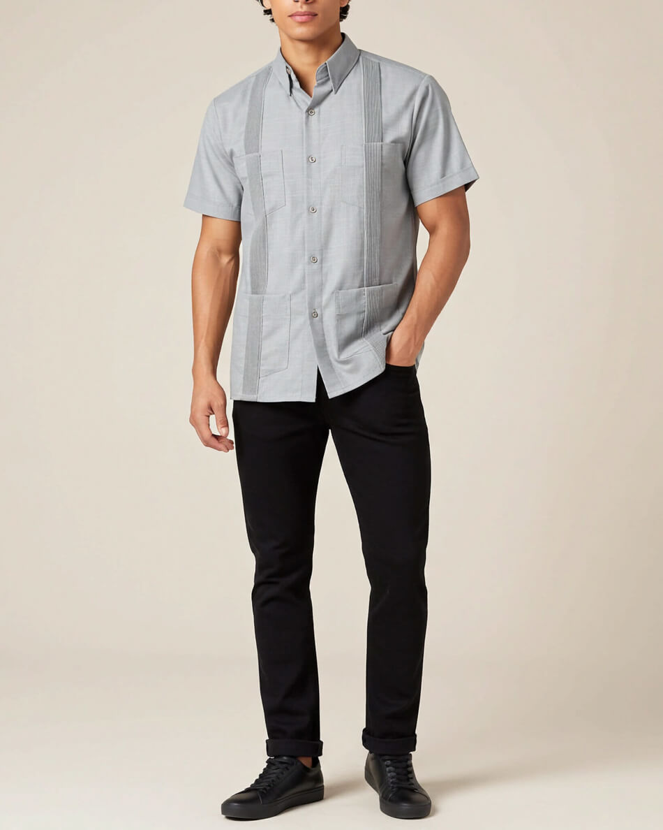 Person wearing a light grey short-sleeve shirt with black pants on a beige background