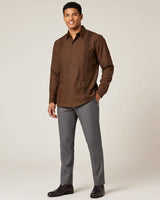Man wearing a brown long-sleeve guayabera shirt with a neutral background