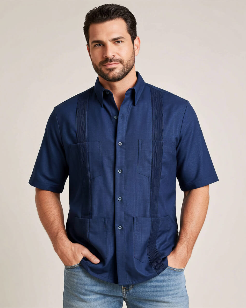 Man wearing a navy blue guayabera shirt with four pockets against a beige background