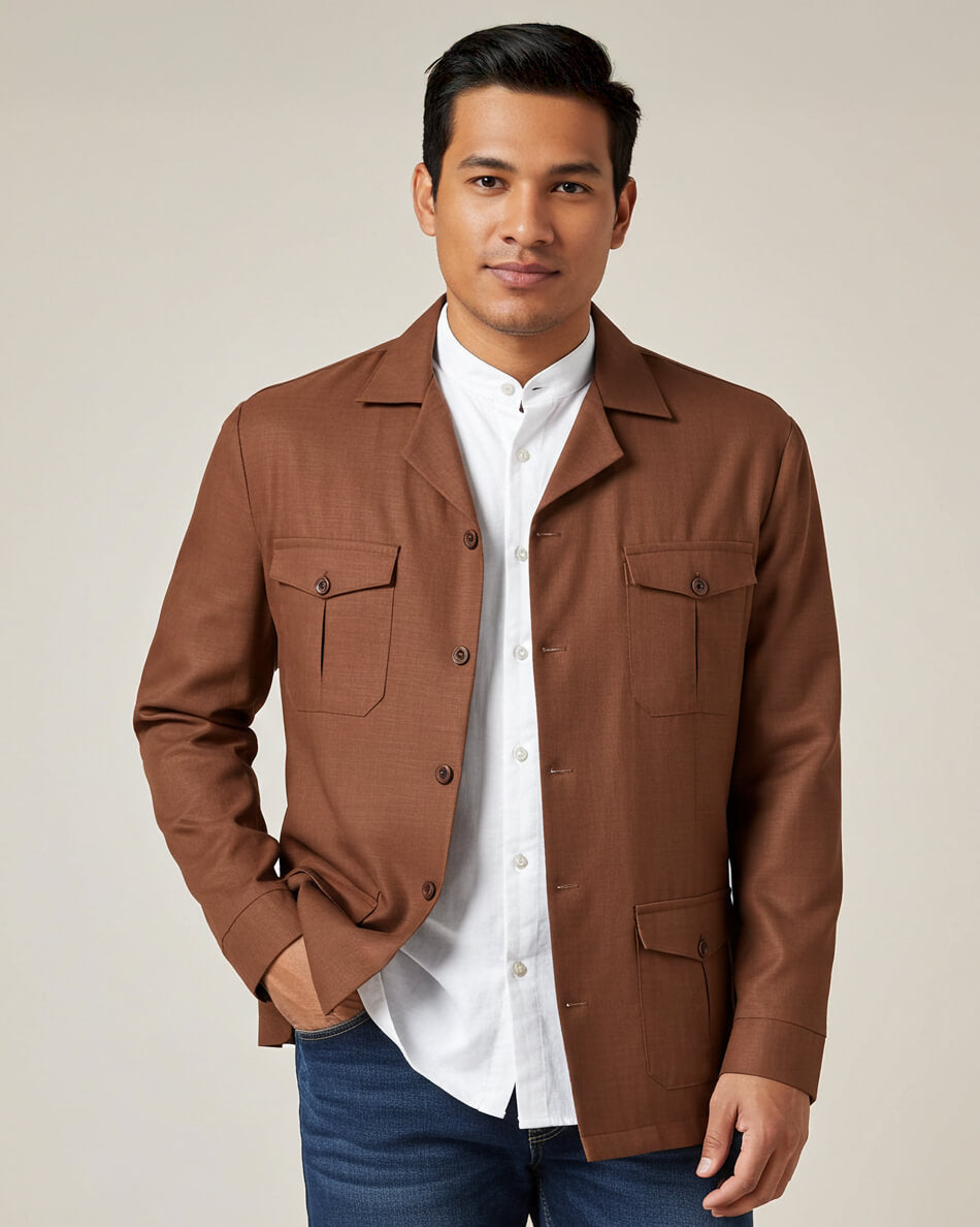 Man wearing a brown guayabera overshirt jacket over a white shirt with a beige background