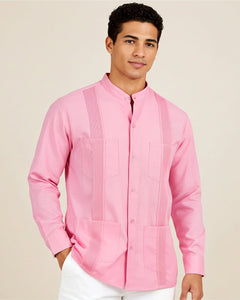 Man wearing a pink long-sleeve guayabera shirt with a subtle pattern on a beige background