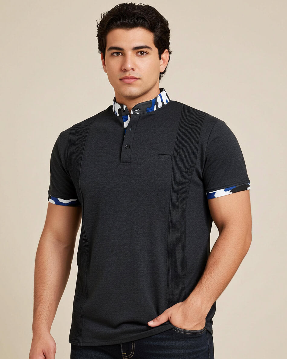 Man wearing a charcoal grey polo shirt with a blue camoflauge collar against a beige background