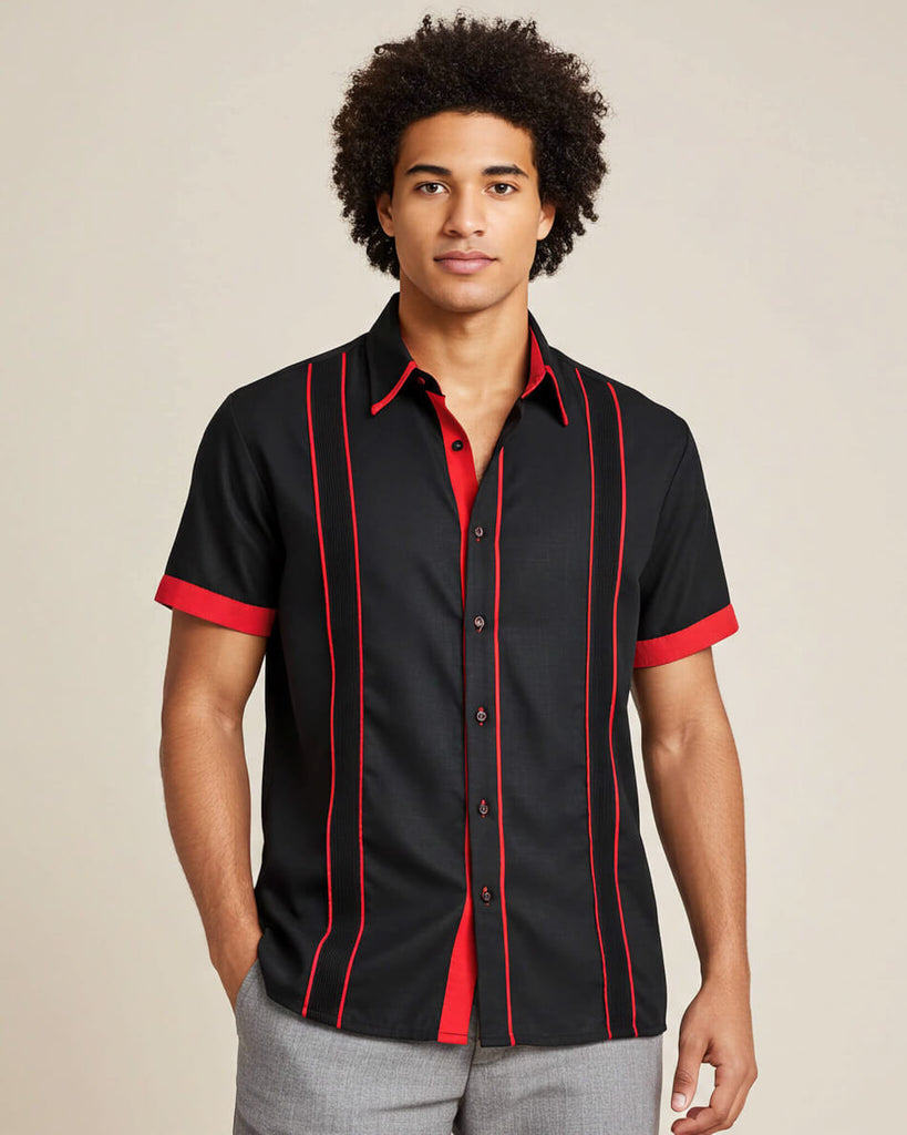 Man wearing a black guayabera shirt with red accents on a beige background