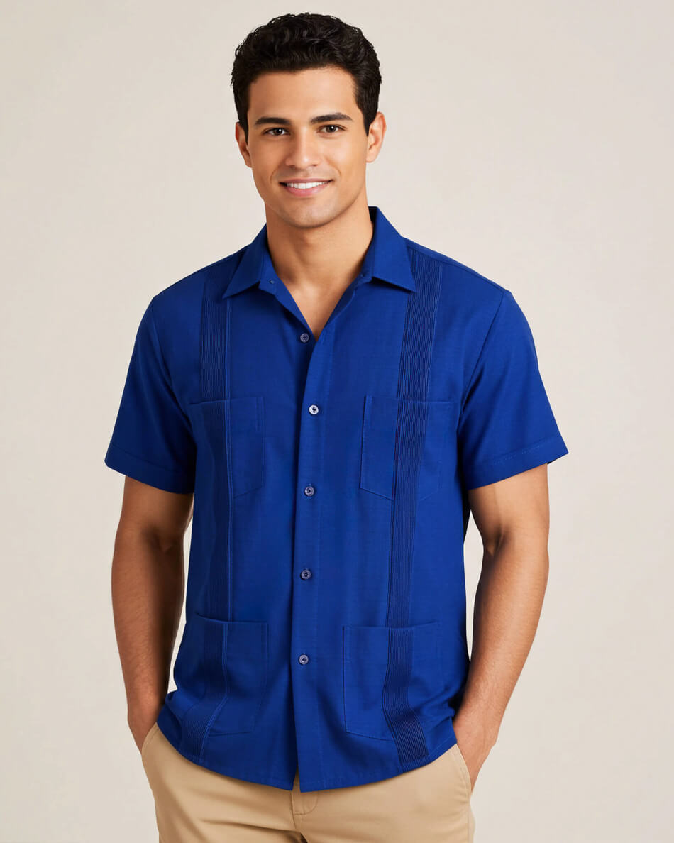 Man wearing a blue short-sleeve guayabera shirt against a beige background