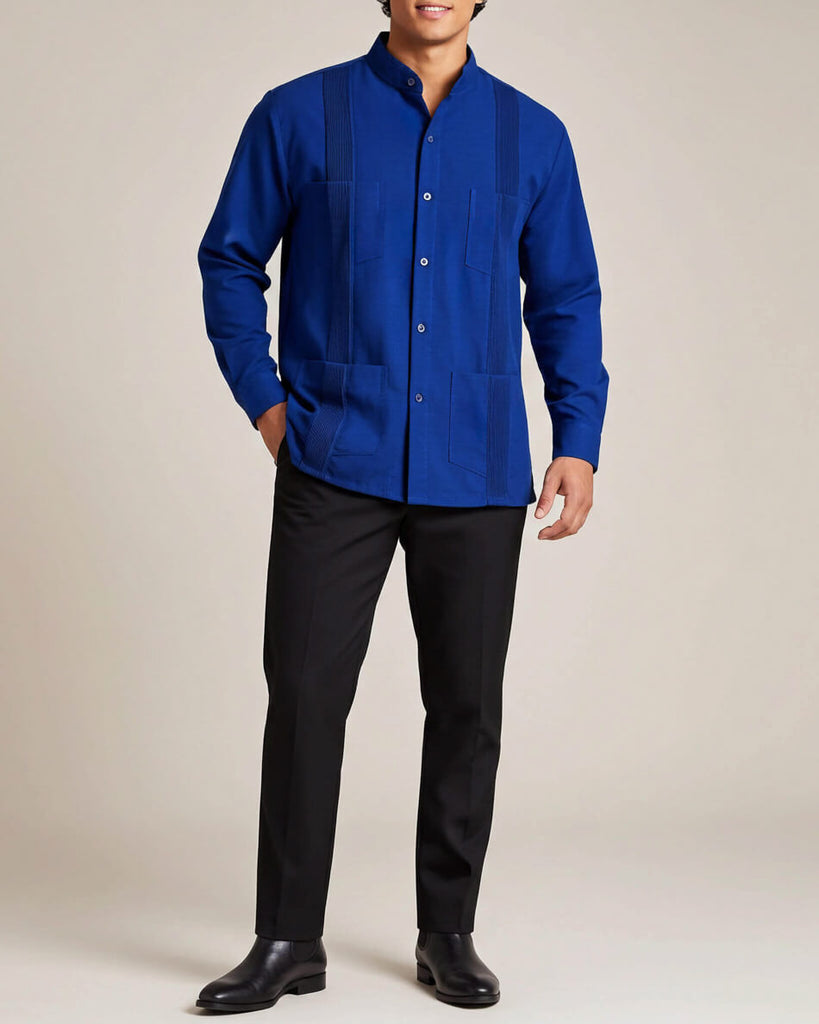 Person wearing a blue guayabera shirt and black pants on a beige background