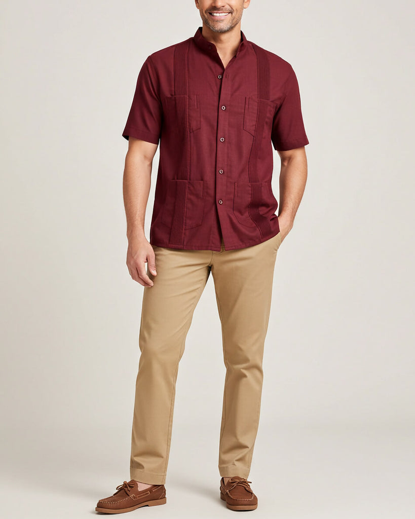 Man wearing a maroon short-sleeve guayabera shirt and beige pants on a plain background