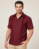 Man wearing a maroon guayabera short-sleeve shirt with pockets on a plain background