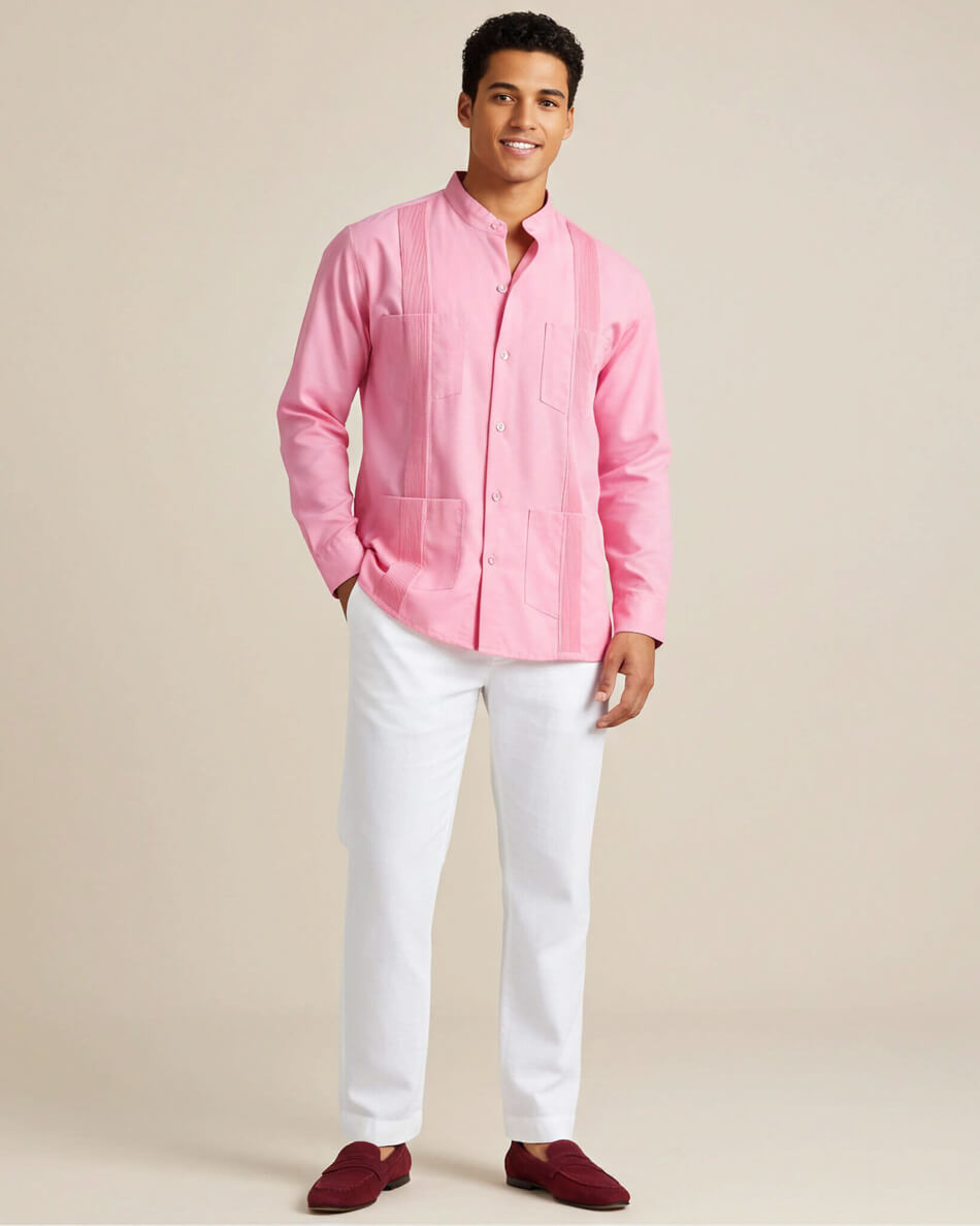 Man wearing a pink guayabera shirt and white pants on a beige background