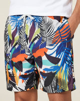 Colorful leaf-patterned shorts worn by a person on a neutral background