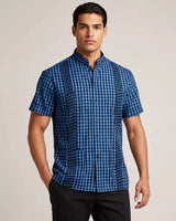Man wearing a blue and black checkered shirt against a plain background