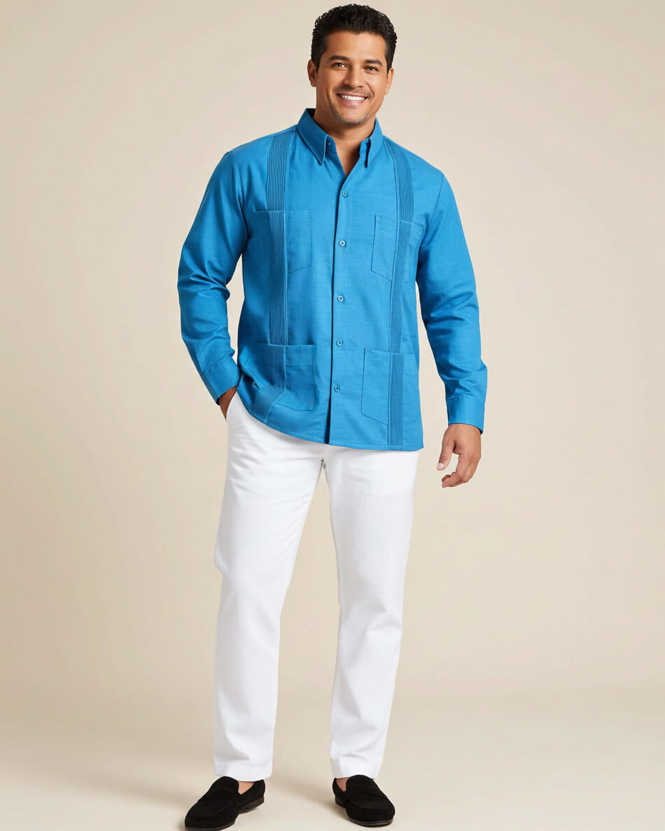 Man wearing a long-sleeve turquoise guayabera and white pants on a beige background