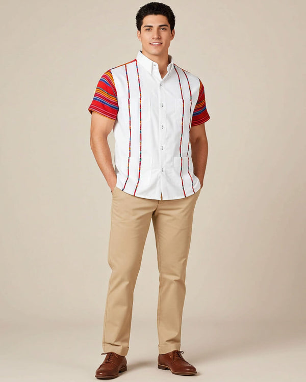 Man wearing a white guayabera shirt with colorful sleeves and beige pants on a beige background