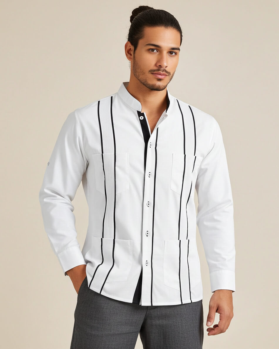 Man wearing a white guayabera shirt with black pleats and gray pants on a beige background