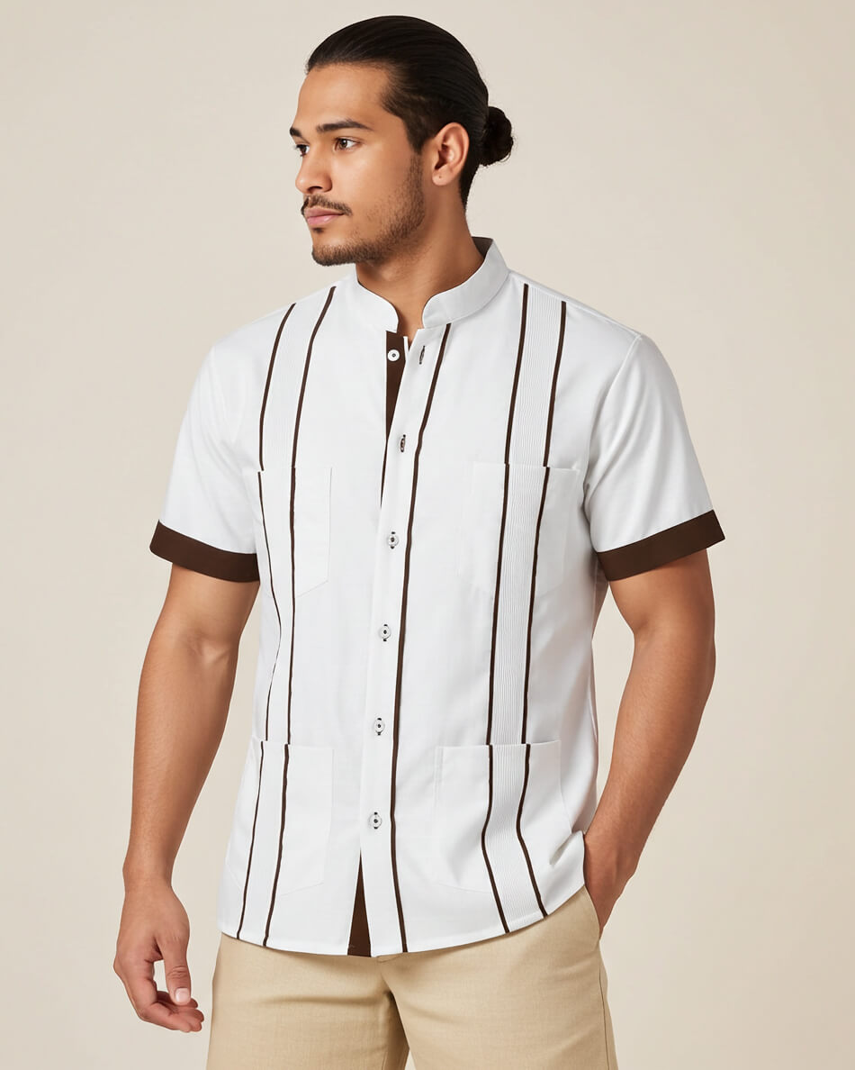 Man wearing a white guayabera shirt with brown accents on a beige background