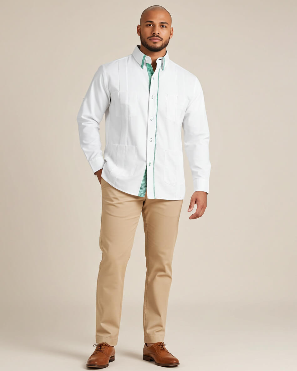 Man wearing a white guayabera shirt with a green accent collar, beige pants, and brown shoes on a beige background
