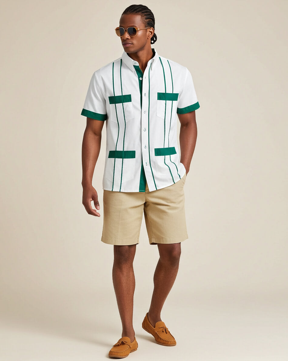 Man wearing a white guayabera shirt with green accents and beige shorts on a beige background