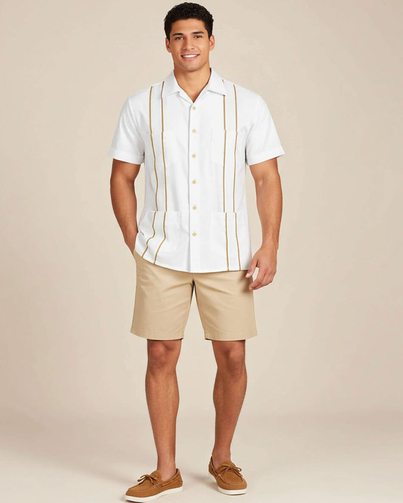 Man wearing a white guayabera shirt with khaki accents and beige shorts on a beige background