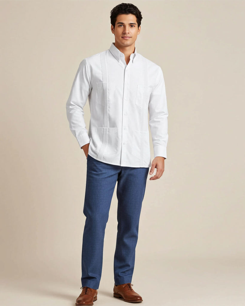 Man wearing a white long-sleeve guayabera shirt and blue pants on a beige background