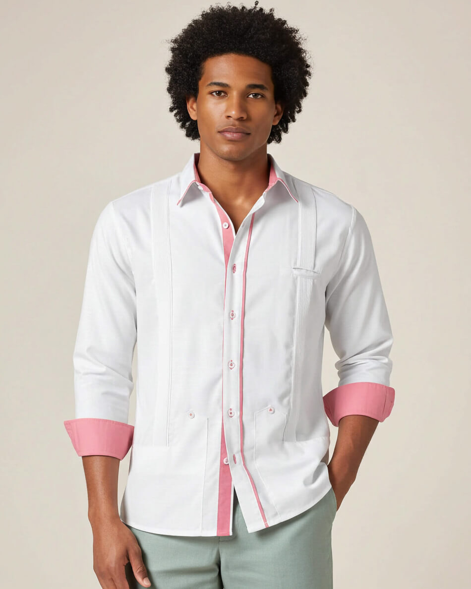 Man wearing a white guayabera shirt with pink accents on a beige background