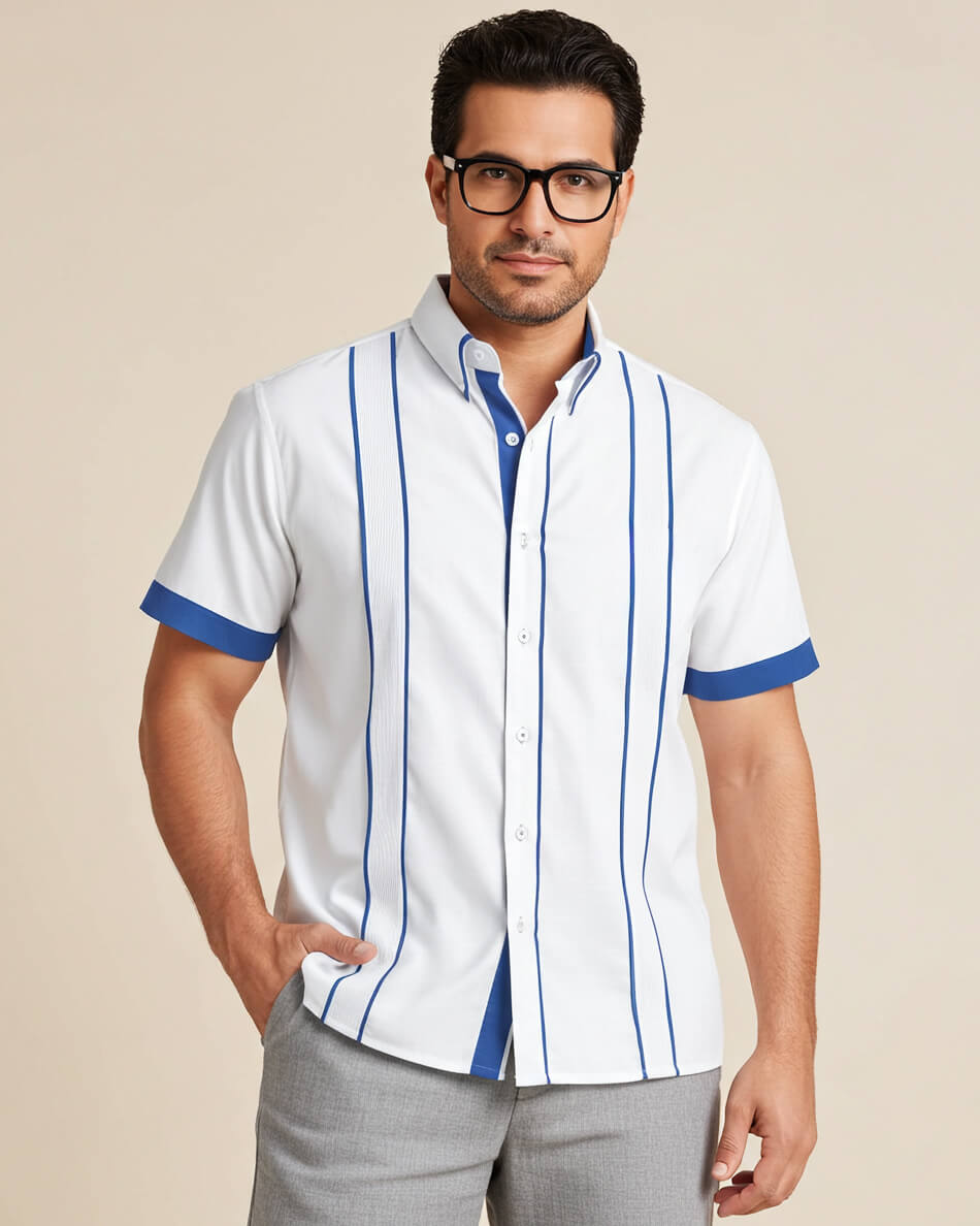 Man wearing a white guayabera shirt with plum blue accents and gray pants on a beige background